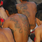 Tattooed backs at a ceremony, By: Rollan Budi