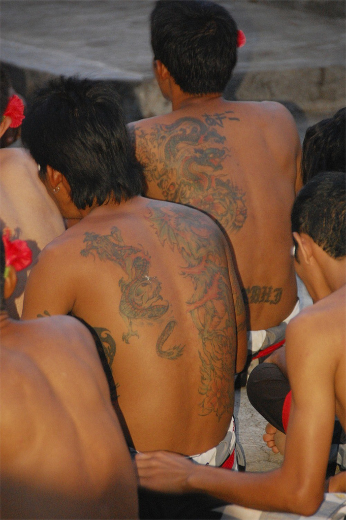 Tattooed backs at a ceremony, By: Rollan Budi